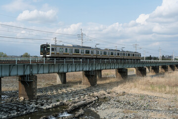 Fototapeta na wymiar 箒川の鉄橋を渡る東北本線の普通列車