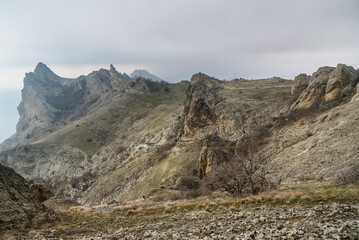Fototapeta premium Devil's fireplace rock and bizarre rocks in Dead city. Khoba-Tele Ridge of Karadag Reserve in spring. Crimea