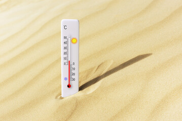 Hot summer day. Celsius scale thermometer in the sand. Ambient temperature plus 8 degrees