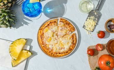 Top view shot of triangle shape piece of delicious tasty Hawaiian traditional Italian crust thin crispy ham and pineapple pizza stretching cheese up from table.