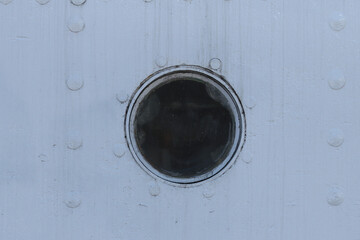 Closed porthole on a ship.