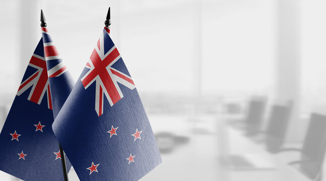 Small flags of the New Zealand on an abstract blurry background