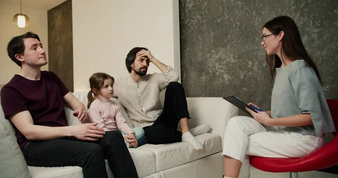 Sad gay couple discussing their relationships with daughter with psychologist