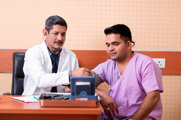 Doctor check up to young patient blood pressure at clinic.