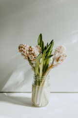 
Beautiful bouquet of hyacinths on a white table with shadows