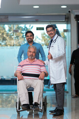 Naklejka premium Doctors giving support to sick old man in a wheel chair
