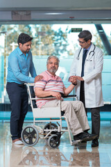 Doctors giving support to sick old man in a wheel chair