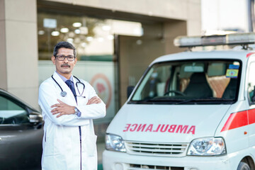 Confident indian male doctor standing at hospital