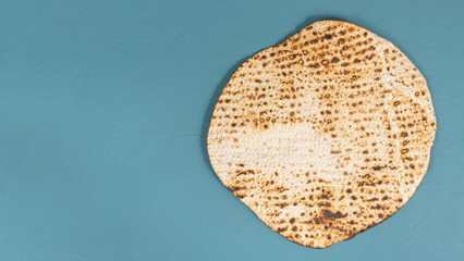 Matzah Shmurah for Jewish holiday Pesach on blue background with copy space.