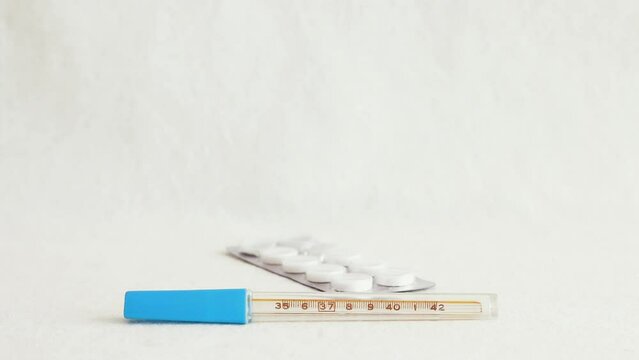 Medicine blisters pack falling down over thermometer