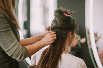 Naklejka premium Gorgeous stylist preparing her client hair for cutting 