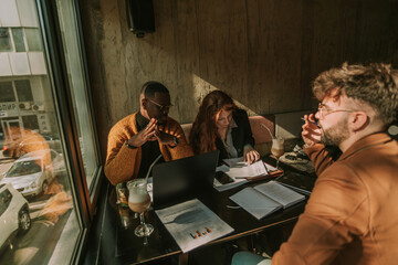 Redhead businesswoman looking for a client name on a document while her white male colleague is talking to their black manager
