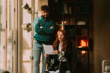 Happy, stylish hipster business couple, discussing business while working together at old school coffee bar out in the city