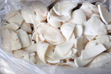 frosted coconut pulp pieces close up photo on white background