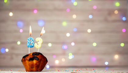 Happy birthday background with muffin and number of candles on light bulbs bokeh background....