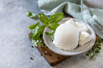 Homemade whey ricotta cheese or cottage cheese with basil ready to eat. Vegetarian healthy diet,...
