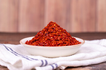 Chilli pepper seedless flakes. Dried red pepper flakes in bowl. Spices and herbs.
