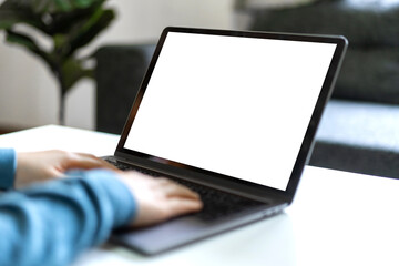 Woman working with modern laptop computer blank white desktop screen for advertising, mockup, technology, advertising, search information, creative design on table