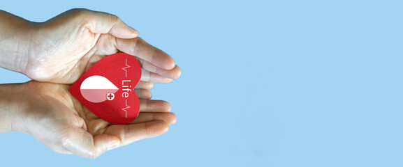 Hand holding red heart and blood drop donation, save life, world hemophilia day concept, world...