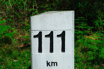 Road concrete marker with a distance 111 km