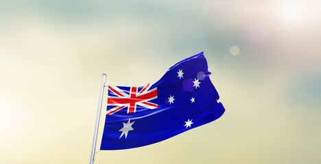 Waving Flag of Australia on blur sky. The symbol of the state on wavy cotton fabric.