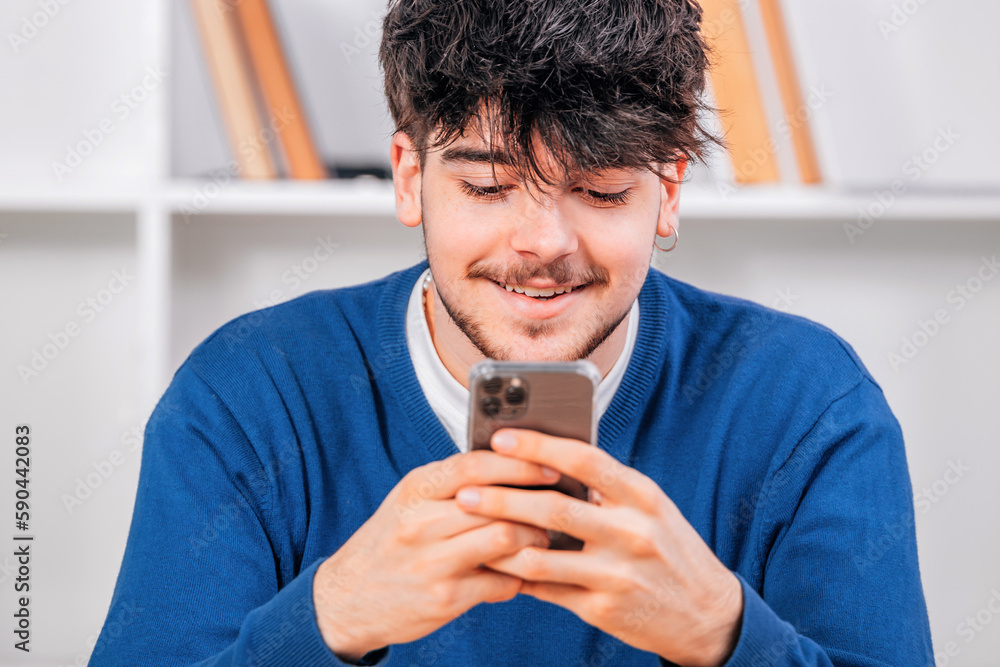 Poster young male student looking at mobile phone smiling