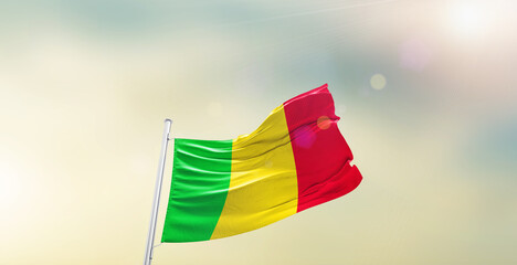 Waving Flag of Mali on blur sky. The symbol of the state on wavy cotton fabric.