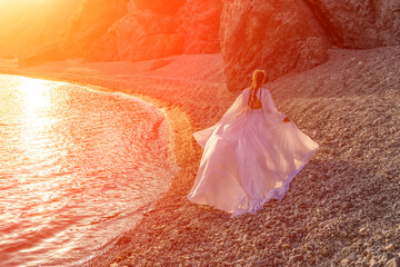 Mysterious woman silhouette long hair walks on the beach ocean water, sea nymph wind listens to the...