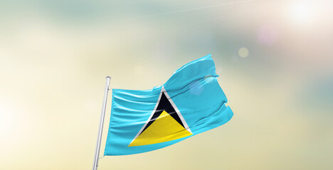 Waving Flag of Saint Lucia on blur sky. The symbol of the state on wavy cotton fabric.