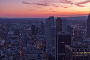 Urban centre at sunset with a pink dusk sky over the high-rises. Frankfurt at sunset with a purple-pink sky 