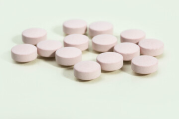 Close up shots of medicine tablets and capsules on white background. White and colored tablets placed in a group.