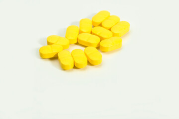 Close up shots of medicine tablets and capsules on white background. White and colored tablets placed in a group.