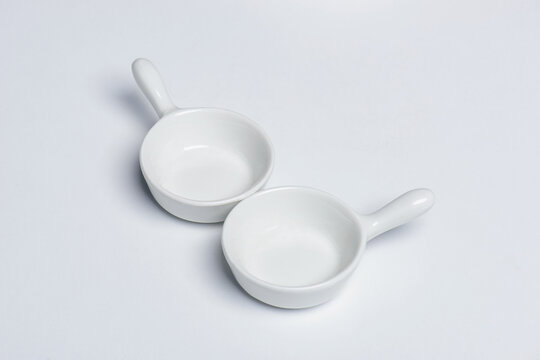 Two small spice bowls with handle, isolated on white