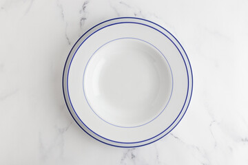 Empty white dinner plate top view on a white background