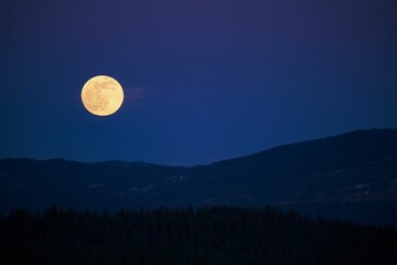 Silhouette of Montana hills under the full moon