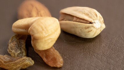 Close-up of pistachios and raisins on brown background