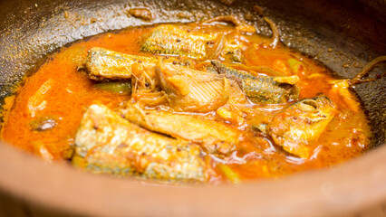 Mackerel fish curry with gravy in tomato sauce in a pot.
