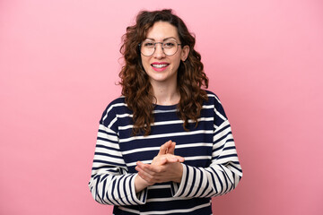 Young caucasian woman isolated on pink background applauding after presentation in a conference