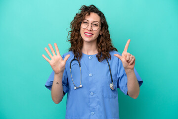 Young nurse caucasian woman isolated on blue background counting seven with fingers