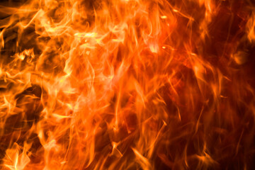 A close-up of a burning orange and yellow flame creates hot atmosphere.