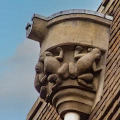 Photo sur Plexiglas Monument historique Sculpture of climbing frogs on a facade of an old building