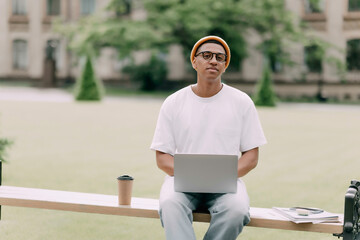 portret of young African American student sitting studying outdoor on a banch and look at the...