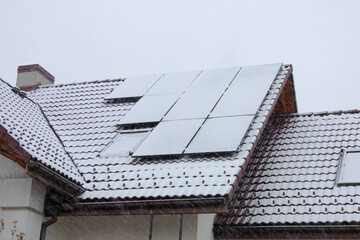 solar panels on the roof covered with snow in winter