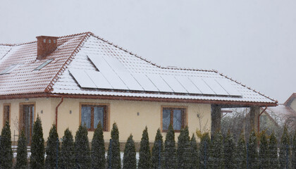 solar panels on the roof covered with snow in winter
