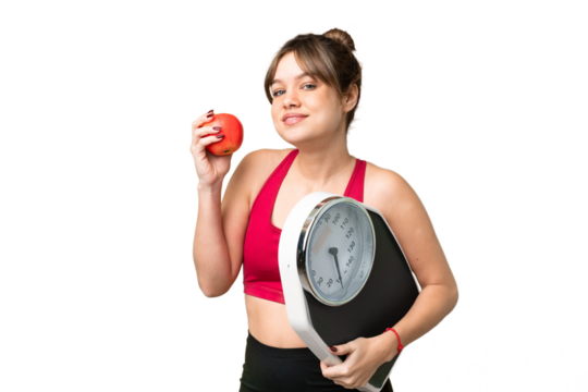 Young girl over isolated chroma key background with weighing machine and with an apple