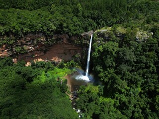 Aerial shot of the Lonecreek falls waterfall surrounded by green forest in Sabie, South Africa.