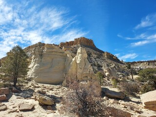 Natural geological formation stones with dry plants under blue cloudy sky on a sunny day