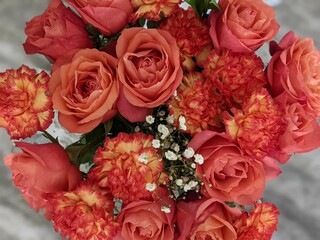Closeup shot of a flower bouquet with red carnations and roses