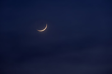 Obraz na płótnie Canvas New moon in the initial phase on a dark night sky
