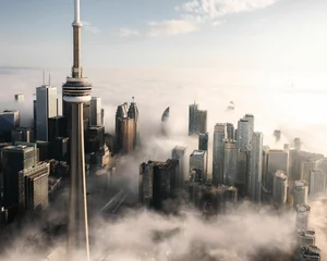  Aerial shot of the tower and other tall buildings covered with clouds, Toronto, Canada © Withkaejon/Wirestock Creators